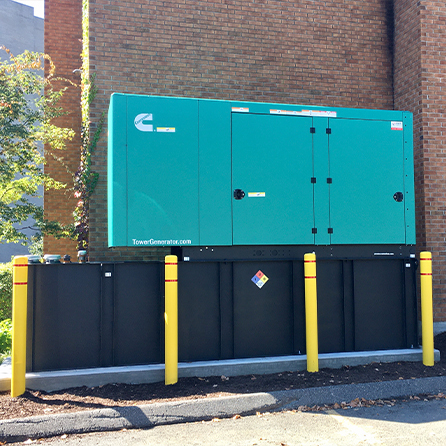 A green Cummins backup generator in the back of a municipal facility.